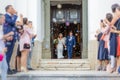 Newlyweds exiting the church after the wedding ceremony, family and friends celebrating their love with the shower of