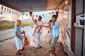 Newlyweds and friends dancing in front of decorated camper rv. Celebration of newlywed love couple. Wedding ceremony, love, nature Royalty Free Stock Photo