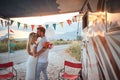 Newlyweds in front of camper rv. Man giving a forehead kiss to bride. Couple in love. Wedding ceremony, love, nature concept