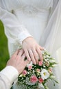 Newlyweds hands and a bouquet of flowers Royalty Free Stock Photo