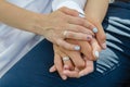 The hands of the bride and groom are intertwined in a tight knot. Wedding ceremony.