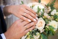 Newlyweds ` hands with rings. Wedding bouquet on the background of the hands of the bride and groom with a gold ring Royalty Free Stock Photo