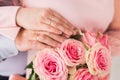 Newlyweds ` hands with rings. Wedding bouquet on the background of the hands of the bride and groom with a gold ring