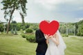 Newlyweds holding a decorative heart. Royalty Free Stock Photo