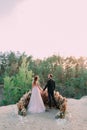 Newlyweds holding hands at the edge of the canyon and couple looking each other with tenderness and love. Outdoors Royalty Free Stock Photo