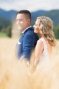 Newlyweds hugging tenderly in wheat field somewhere in Slovenian countryside. Caucasian happy romantic young couple Royalty Free Stock Photo