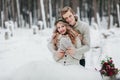 Newlyweds are hugging in the winter forest. Couple in love. Winter wedding ceremony.