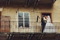 Newlyweds kiss on an old half-ruined balcony