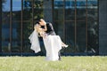 Newlyweds kiss under a veil on background willow