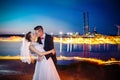 Newlyweds kissing near lake by night