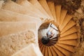 Newlyweds lie holding hands on the spiral staircase of the ancient castle. View from above Royalty Free Stock Photo