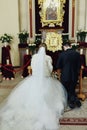 Newlyweds pray on kneels in the front of icon in the church