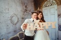 Newlyweds reach out their hands with wooden lettering HAPPY