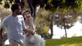 Newlyweds run in park in summer. Action. Beautiful loving couple romantically run away holding hands in park. Wife in