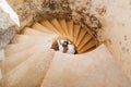 Newlyweds are seen through the spiral staircase of the ancient castle. View from above Royalty Free Stock Photo