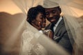 Newlyweds stand under bridal veil, embrace and smile in canyon a Royalty Free Stock Photo