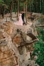 Newlyweds standing at the edge of the rock and couple looking each other with tenderness and love. Bride and groom Royalty Free Stock Photo