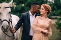 Newlyweds are standing near a white horse in nature Royalty Free Stock Photo