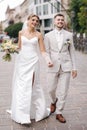 Newlyweds walking in the city centre in Europe. Beautiful wedding couple surrounded of old architecture Royalty Free Stock Photo