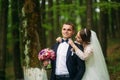 The newlyweds are walking in the park on the wedding day. The bride and groom Enjoying at the wedding day. Sunny weather Royalty Free Stock Photo