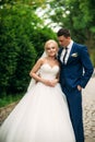 The newlyweds are walking in the park on the wedding day. The bride and groom Enjoying at the wedding day. Sunny weather. Royalty Free Stock Photo