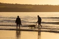 Couple walking their dog on the shore at Newport Beach, Pembrokeshire, Wales. Royalty Free Stock Photo