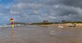 Panorama view of Fistral Beach in Newquay with lifeguard watching over swimming zone marked with flags