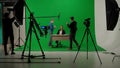 News anchor at work, process of preparing for news shooting, view of a backstage studio TV news shooting, chroma key