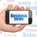 News concept: Hand Holding Smartphone with Business News on display Royalty Free Stock Photo