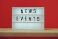 News Events word in light box on red and wooden shelves background Royalty Free Stock Photo