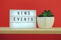 News Events word in light box on red and wooden shelves background Royalty Free Stock Photo