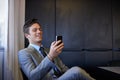 The news that made his day. a handsome young businessman using his mobile phone while sitting at his desk. Royalty Free Stock Photo