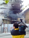 News reporter and burning building