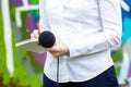 News reporter or TV journalist at press conference, holding microphone and writing notes Royalty Free Stock Photo