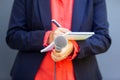 Female journalist at news conference or media event, writing notes, holding microphone Royalty Free Stock Photo