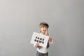 Newsboy shouting against grunge wall background. Boy selling fake news