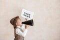 Newsboy shouting against grunge wall background. Boy selling fake news