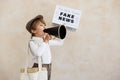 Newsboy shouting against grunge wall background. Boy selling fake news