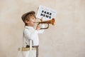 Newsboy shouting against grunge wall background. Boy selling fake news