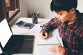 Newsletter concept Hand of business young man writing notebook with mock up digital laptop Vintage tone filter.Top view. Selective Royalty Free Stock Photo