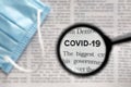 Newspaper Article with the Headline Covid 19. News about Coronavirus Pandemic on a newspaper through a magnifying glass Royalty Free Stock Photo