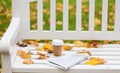 Newspaper and coffee cup on bench in autumn park Royalty Free Stock Photo