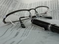 Newspaper with glasses and pen Royalty Free Stock Photo