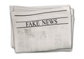 Newspaper with headline Fake News isolated on white background Royalty Free Stock Photo