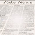 Newspaper with headline Fake News and old unreadable text Royalty Free Stock Photo