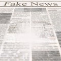 Newspaper with headline Fake News and old unreadable text Royalty Free Stock Photo