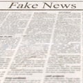 Newspaper with headline Fake News and old unreadable text Royalty Free Stock Photo