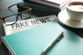 Newspaper with notebook and cup of coffee on table Royalty Free Stock Photo