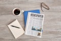 Newspaper, notebooks and cup of coffee on wooden table Royalty Free Stock Photo