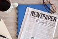 Newspaper, notebooks and cup of coffee on wooden table Royalty Free Stock Photo